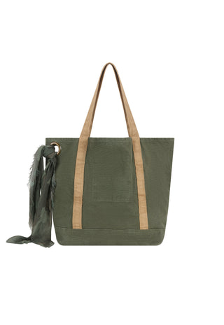 An olive green canvas tote bag with tan shoulder straps and a matching dark green scarf hanging from a metal ring on the left side, shown against a plain white background.