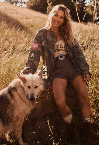  wearing a cream tank top with 'SPELL' printed on the front
